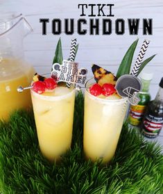 two cocktails with pineapple garnish sit in the grass