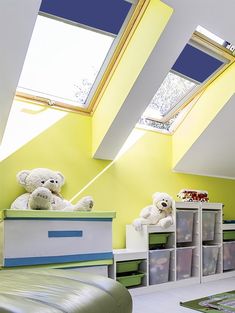 two teddy bears sitting on top of boxes in a child's room with skylights