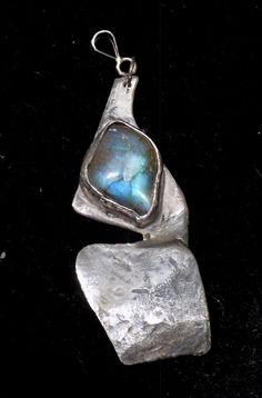 Add a touch of elegance to your jewelry collection with this exquisite handmade sterling silver 925 necklace pendant featuring a striking labradorite stone. This one-of-a-kind piece is meticulously crafted with attention to detail, making it a perfect statement accessory for any outfit. Elevate your style with this unique contemporary pendant that combines the beauty of sterling silver with the mesmerizing hues of labradorite. Perfect for both casual and formal occasions, this pendant is sure to Unique Silver Labradorite Necklace, Unique Labradorite Pendant Necklace, Silver Hand Forged Labradorite Necklace, Silver Labradorite Hand Forged Necklace, Hand Forged Silver Labradorite Necklace, Contemporary Pendant, Silver 925 Necklace, Labradorite Pendant, Labradorite Stone