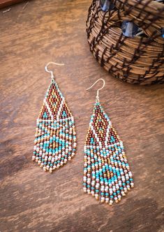 These geometric, psychedelic inspired earrings are sure to make heads turn. Groovy shapes of white, blue, copper and gold make a statement accessory and are on the larger side of earrings in the shop, measuring a 2.5 inch drop length and a width of 2.25 inches. All jewelry in the store is handmade with care and love in the US. Crafted from glass Czech seed beads and hypoallergenic metal ear hooks. CARE FOR YOUR HANDMADE JEWELRY: ● Earrings and bracelets can be cleaned with a water damp cloth.  ● White Bohemian Geometric Earrings, White Geometric Bohemian Earrings, Bohemian White Geometric Earrings, Handmade Blue Geometric Earrings, Blue Bohemian Jewelry With Geometric Shape, Bohemian Blue Geometric Earrings, Blue Bohemian Geometric Jewelry, Bohemian Blue Geometric Jewelry, Stitch Earrings