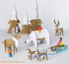 paper cut out animals and people on sleighs in front of snow - covered trees