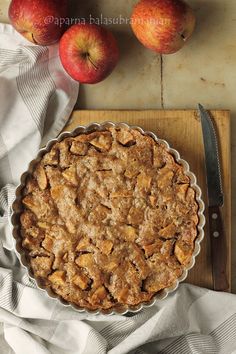 an apple pie sitting on top of a wooden cutting board