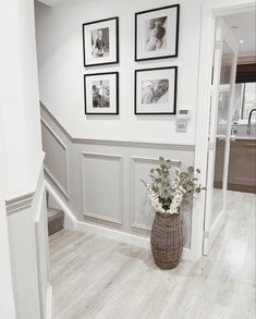 a vase filled with flowers sitting on top of a hard wood floor next to stairs