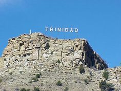 there is a sign on top of the mountain that says trindad in spanish