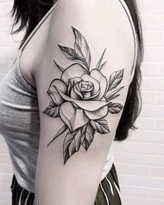 a woman's arm with a rose tattoo on the left side of her arm