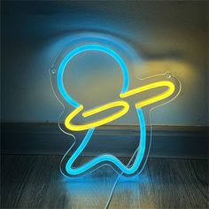 a neon sign with a person holding a circular object in it's hand on a wooden floor