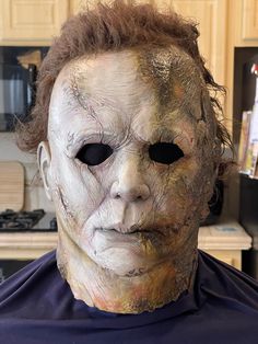 a man wearing a creepy mask in the kitchen