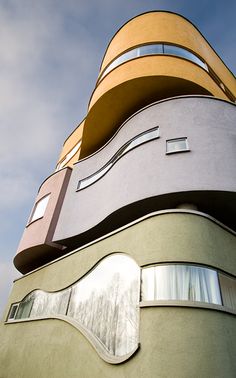 a tall building with many windows on it's side and the sky in the background