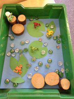 a green tray filled with lots of different types of buttons and magnets on it