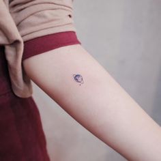 small saturn tattoo on the left inner arm