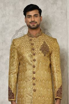 Gold jamewar sherwani with hand embroidery.
Components: 1
Pattern: Hand embroidered
Neckline: Mandarin collar
Sleeve Type: Full
Fabric: Jamewar
Color: Gold
Other Details: 
Overlapping placket on sherwani
Closure : Sherwani - Front buttons
Note : Churidar worn by the model is not sale.
Occasion: Mehendi and Puja,Sangeet - Aza Fashions Semi-stitched Gold Kurta With Naqshi, Bollywood Gold Salwar Kameez With Naqshi, Designer Gold Sets With Naqshi Detailing, Traditional Raw Silk Wear With Naqshi Detailing, Festive Raw Silk Sherwani With Dabka Work, Gold Sherwani With Zari Work For Designer Wear, Traditional Naqshi Raw Silk Traditional Wear, Designer Wear Gold Sherwani With Resham Embroidery, Traditional Gold Raw Silk Wear With Naqshi