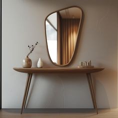 a wooden table with a mirror and vase on it