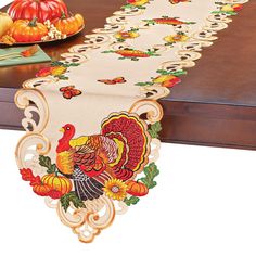 a table runner with a turkey on it and pumpkins in the backgroud