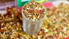 a glass filled with lots of different types of granola on top of a table