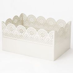 a white paper box with laser cut designs on the front and sides, sitting on a white surface