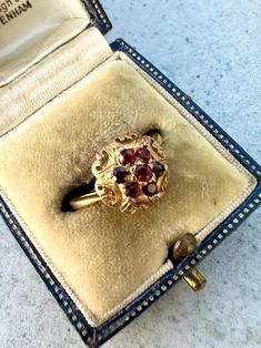 This is a vintage 9ct Gold Garnet Cluster Ring. 7 vibrant garnets create a lovely cluster and are set in a decorative yellow gold setting. Ring size N  Weight: 2.69 grams approximately. The ring is marked with full London hallmarks, 9. 375 for 9ct Gold and dates to 1967. Please note all sizes and measurements are approximate. Comes with box. Box may differ from that in photos. As most of our pieces are vintage finds they only come in one size. However if you require your ring to be sized so it's Vintage Style Red Cluster Ring In 14k Gold, Vintage Red Garnet Cluster Ring, Vintage Garnet Birthstone Rings, Vintage Garnet Cluster Ring As Gift, Vintage Garnet Cluster Ring For Anniversary, Vintage 14k Gold Birthstone Ring, Vintage Ruby Ring Gift, Vintage Garnet Birthstone Ring In Yellow Gold, Vintage Gold Garnet Birthstone Ring