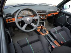 the interior of a car with black leather and orange trim