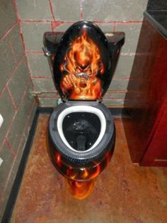 the toilet is decorated with flames and skulls