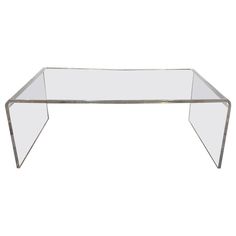 a glass and metal coffee table on a white background with the top half turned upside down