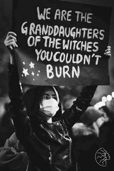 a woman holding up a sign that says we are the granddaughters of the witches you couldn't burn