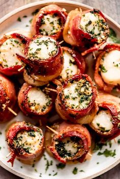 small appetizers with meat and cheese are on a white plate, ready to be eaten