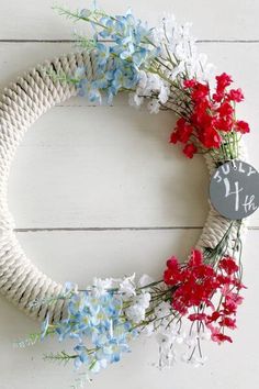 a white rope wreath with red, white and blue flowers on it that reads 11 th