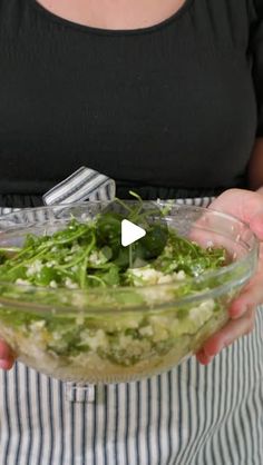 a woman holding a bowl filled with salad