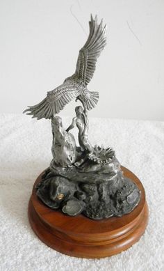 a statue of two people and an eagle on top of a rock