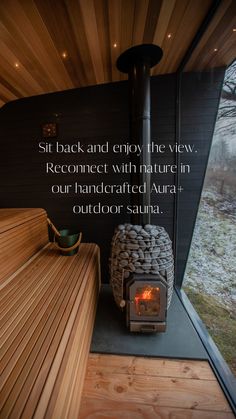 a wood burning stove sitting inside of a wooden room next to a wall with a quote on it