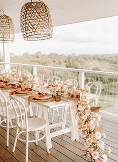 an outdoor dining area with white chairs and tables set up on the deck for dinner