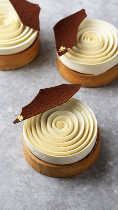 three desserts with white frosting and brown leaves on top are arranged in rows