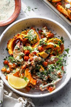 a white bowl filled with food next to other dishes