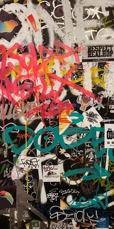 a wall covered in graffiti and stickers