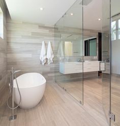 a bathroom with a large tub and two towels hanging on the wall next to it