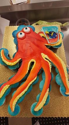 an orange and blue octopus cake sitting on top of a counter