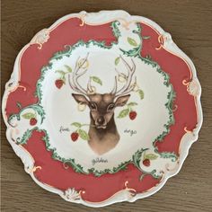 a decorative plate with a deer's head and berries on the rim is shown