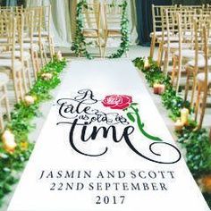 an aisle decorated with roses and greenery for a wedding at the end of the aisle