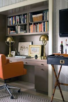 black and white photograph of a home office with desk, chair, bookshelf and television