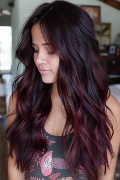 Woman with long, wavy, dark hair with burgundy highlights, looking down and smiling slightly. Burgundy Hair On Dark Hair, Deep Red Hair Color Balayage, Red Burgundy Highlights, Dark Brown With Burgundy Balayage, Brown Burgundy Ombre Hair, Merlot Bayalage Hair, Brunette New Hair Ideas, Dark Red Dimensional Hair Color, Dark Cherry Ombre Hair