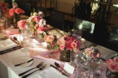 the table is set with flowers and silverware