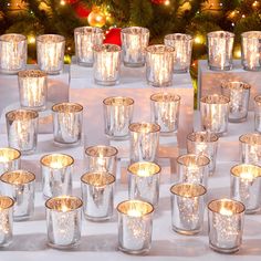 many lit candles are placed on a table