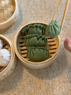 two baskets filled with dumplings on top of a counter next to chopsticks