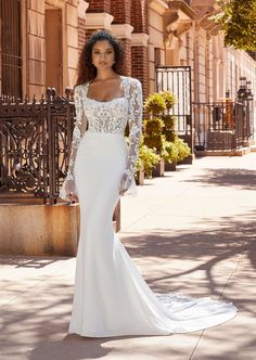 a woman in a wedding dress standing on the sidewalk