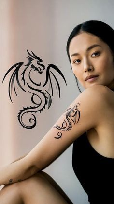 a woman with a dragon tattoo on her arm sitting in front of a wall and looking at the camera