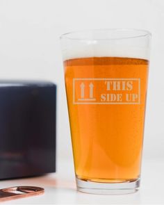 a glass of beer sitting next to a cell phone