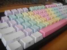 a computer keyboard sitting on top of a wooden desk