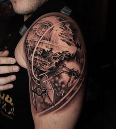 a man's arm with a star wars tattoo on it and an image of a spaceship