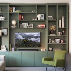 a living room filled with furniture and a flat screen tv sitting on top of a wooden shelf