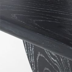 a close up view of the top of a table with black wood grained finish