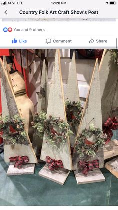 four wooden christmas trees with bows and greenery on them are displayed in front of a facebook post